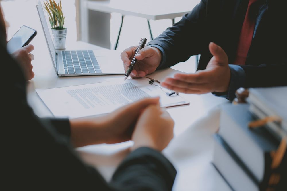 OpenText-ECM-Beratungsgespräch am Tisch mit Laptop und Unterlagen